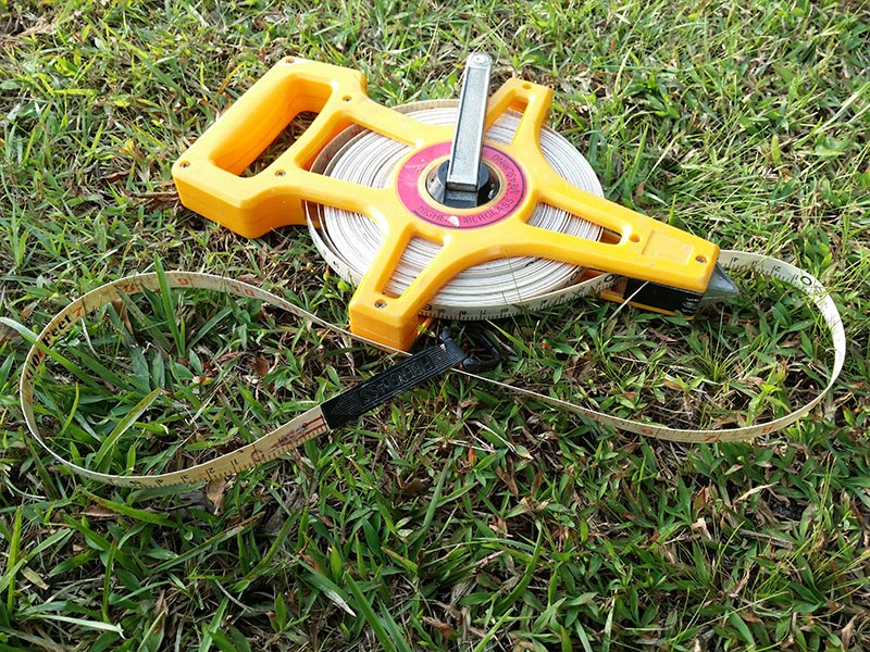 Tape measure in the grass of a homeowners backyard